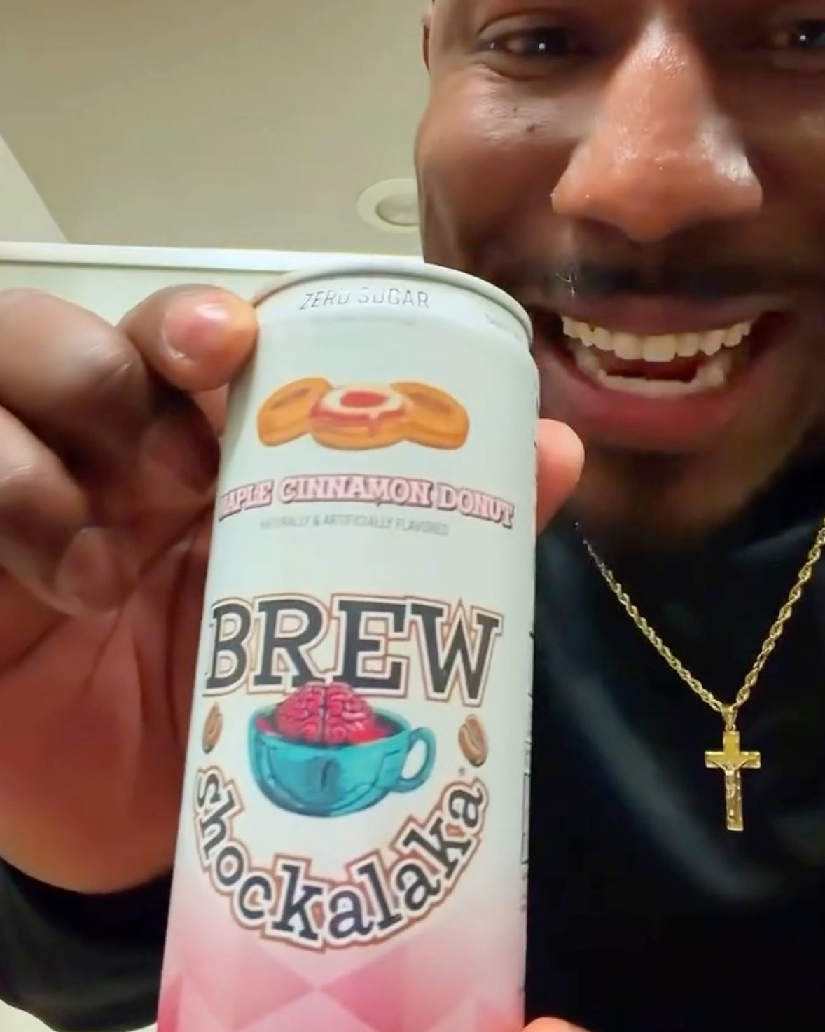 Person holding a can of 'Brew Shockalaka' with a smile