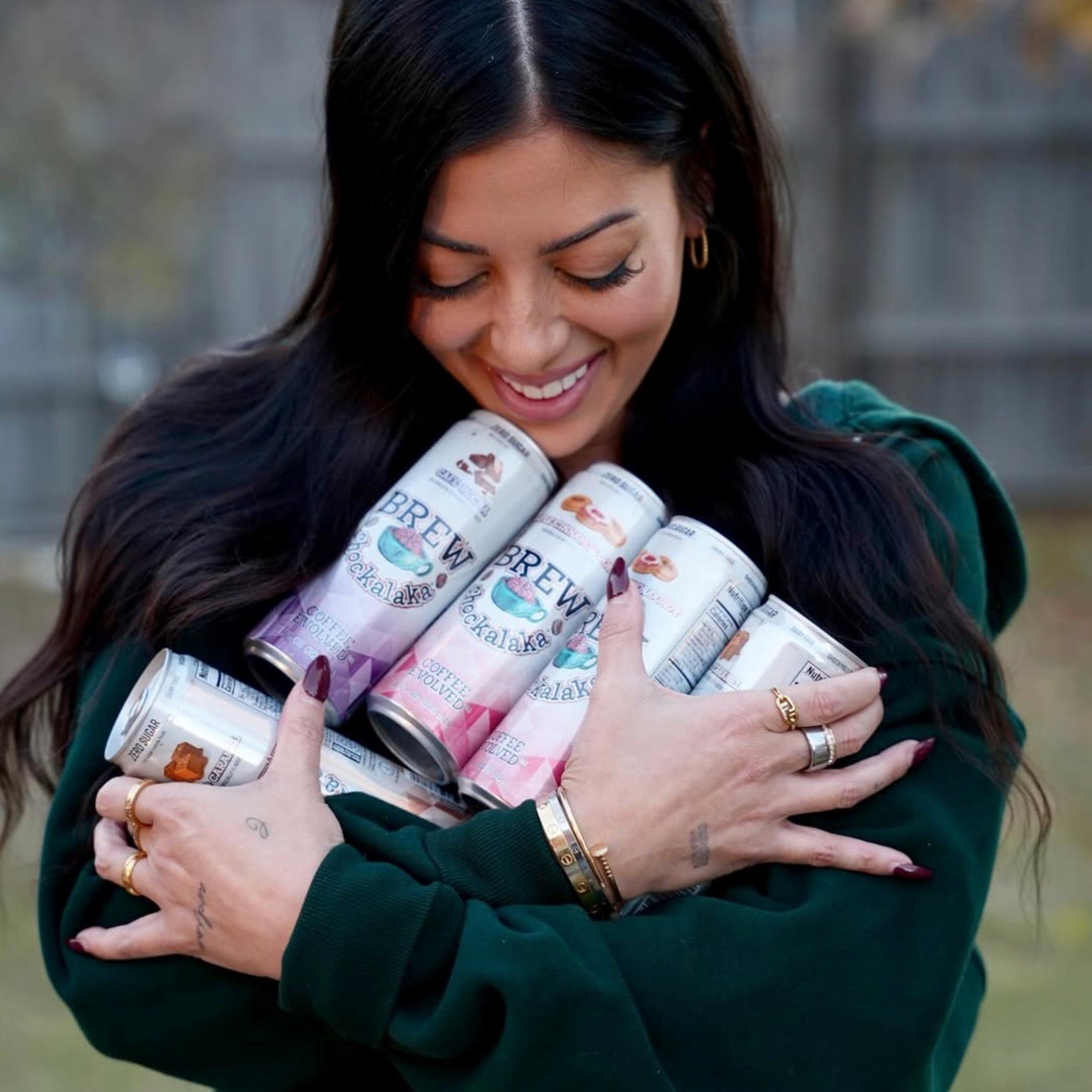 Woman holding a stack of Przewalski's beer cans outdoors